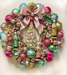 a christmas wreath with ornaments hanging on the front and side of it, all in different colors