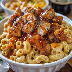 a white bowl filled with pasta covered in sauce and chicken wings on top of it