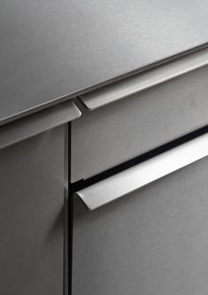 a close up view of the handles on a stainless steel dishwasher and refrigerator