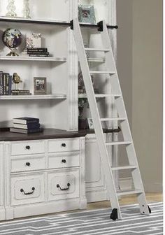 a ladder leaning up against a white bookcase with books on top and drawers below