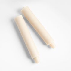 two candles sitting next to each other on a white surface