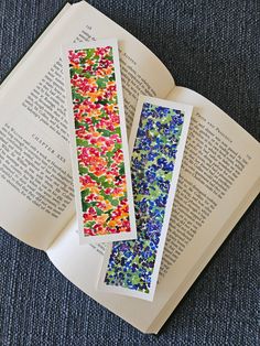 two bookmarks are sitting on top of an open book that has been decorated with colorful sprinkles