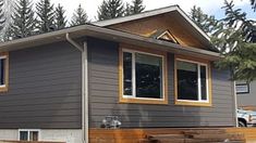 a gray house with wood trim and windows