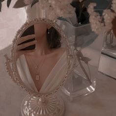 a mannequin's head in front of a mirror with flowers on it