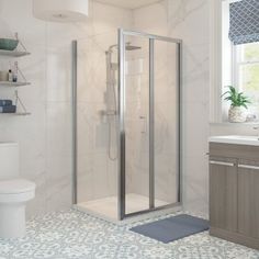 a bathroom with a toilet, sink and shower stall in the middle of the room