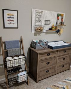 a baby's room with a dresser, crib and toy storage bins