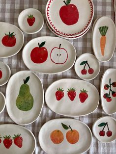 many plates with fruits and vegetables painted on them are laid out in the shape of bowls