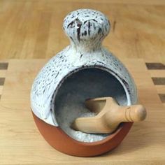 a ceramic vase sitting on top of a wooden table