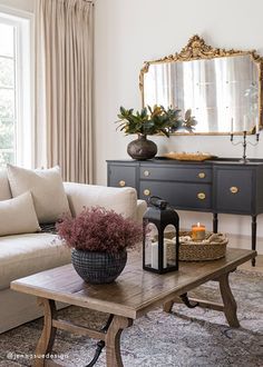 a living room filled with furniture and a large mirror on the wall over a table