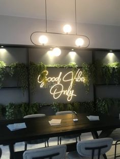 a conference room with tables, chairs and plants on the wall