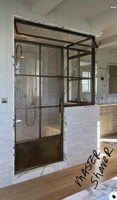 a bathroom with a glass shower door and wooden floors