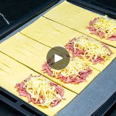 two uncooked pizzas sitting on top of a baking sheet in an oven