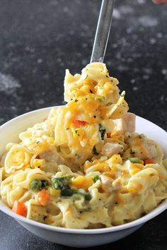 a bowl filled with pasta and chicken on top of a table