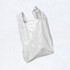 a plastic bag floating in the air on a white surface with no one around it