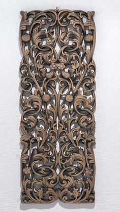 an intricately carved wooden panel with vines and leaves on it's sides, against a white background