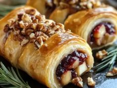 cranberry and walnut pastry rolls on a platter with pine sprigs