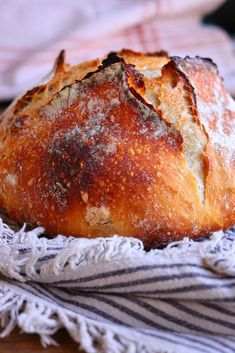 a loaf of bread sitting on top of a table next to a striped towel and napkin