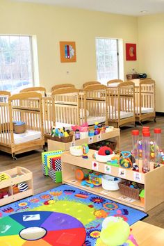 a child's playroom with wooden cribs and toys