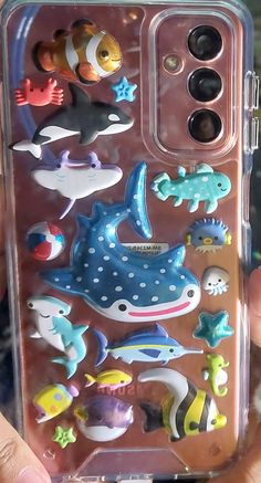 someone is holding their phone case with various sea animals on it