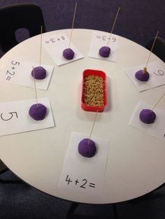 a white table topped with lots of purple apples