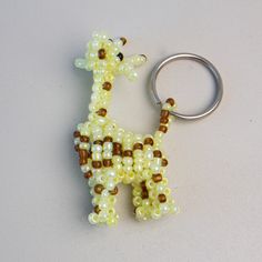 a beaded giraffe keychain is shown on a white surface