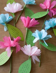 paper flowers are arranged on top of each other with green leaves and words written on them