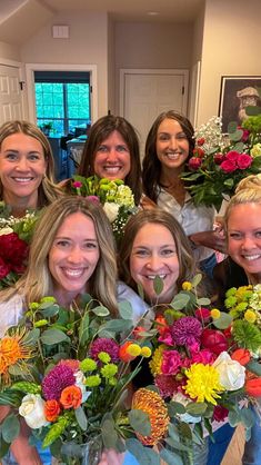 a group of women standing next to each other holding flowers