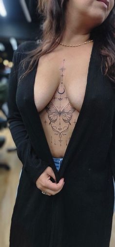 a woman with tattoos on her chest is posing for the camera