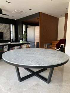 a round table sitting in the middle of a living room next to a tv set