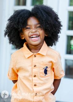 a young boy with an afro smiles for the camera