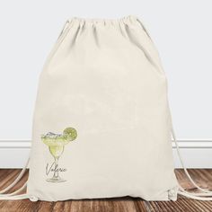 a drawstring bag with an image of a drink in it on the floor