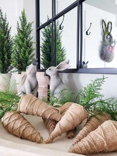 some stuffed animals sitting on top of a table next to plants and trees in front of a mirror