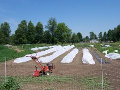 a tractor is parked in the middle of an open field with bags on top of it