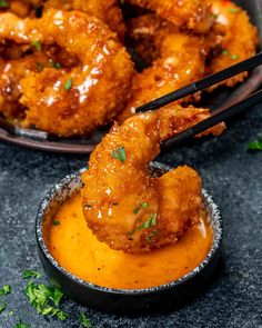 two bowls filled with chicken wings and sauce