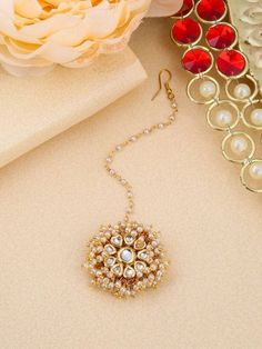 a close up of a necklace on a table with flowers and other items in the background