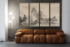 a living room with three paintings on the wall and a couch in front of it