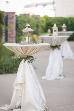 two tables with white cloths and candles on them are set up for an outdoor ceremony