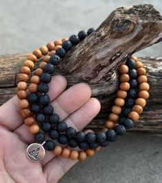 Experience the perfect harmony of nature and spirituality with this beautifully handcrafted 108-bead mala. Made with calming sandalwood and grounding lava stones, this mala is a versatile tool for meditation, prayer, or as a meaningful piece of jewelry. Key Features: ❤ Sandalwood Beads: Known for their soothing aroma and calming energy, ideal for promoting inner peace. ❤ Lava Stone Beads: Porous, grounding stones that can also absorb and diffuse essential oils for aromatherapy. ❤ Bead Count: 108 beads, following the sacred tradition of mantra recitation. ❤ Design: Simple, elegant, and versatile for meditation or daily wear. ❤Free Gift: Includes a soft, high-quality silk mala bag for safekeeping and easy storage. ❤ Size: Beads approximately 8mm. Length is 30 Inches from one end to another e Diffuse Essential Oils, Rudraksha Mala, Meditation Prayer, Beads Mala, 108 Mala Beads, 108 Bead, Lava Stone, Mala Beads