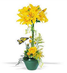 a green vase filled with yellow flowers and butterflies