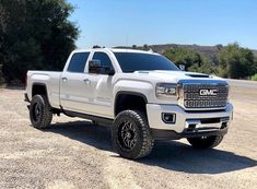 a white truck is parked in the dirt