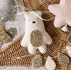 a white teddy bear sitting on top of a wicker basket next to other decorations