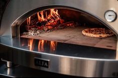 a pizza is cooking in an oven with fire coming from the top and on it's side