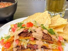 a white plate topped with a taco sandwich and tortilla chips