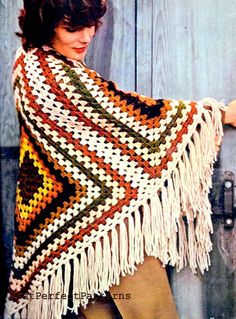 a woman wearing a crocheted shawl with fringes