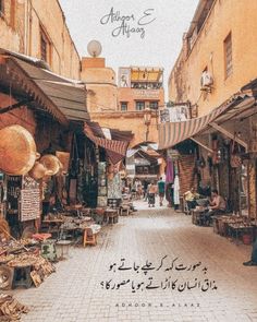 an alley way with shops and people in arabic writing on the side walk, surrounded by buildings