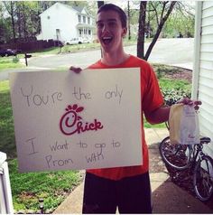 a man holding up a sign that says you're the only chick i want to go to prom with