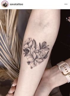 a woman's leg with a flower tattoo on the left side of her arm