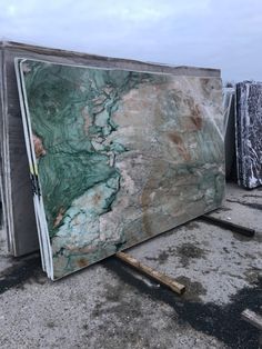 a large marble slab sitting on top of a parking lot next to other pieces of wood