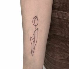 a single line tulip tattoo on the left arm