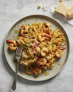 a plate of pasta with shrimp and parmesan cheese